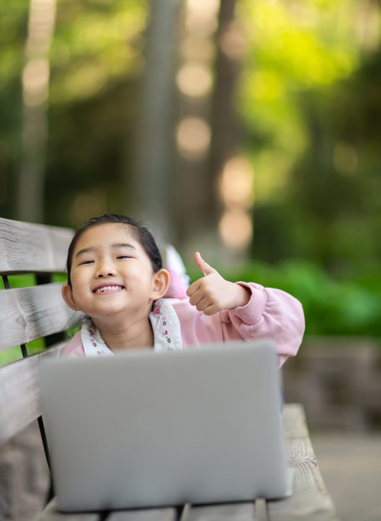 Little Girl Using Laptop and Thumbs up