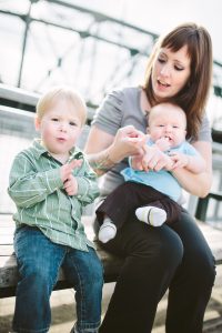 A mother communicates with sign language with her toddler aged boy as they play in an urban environment. Taken in downtown Portland, Oregon.